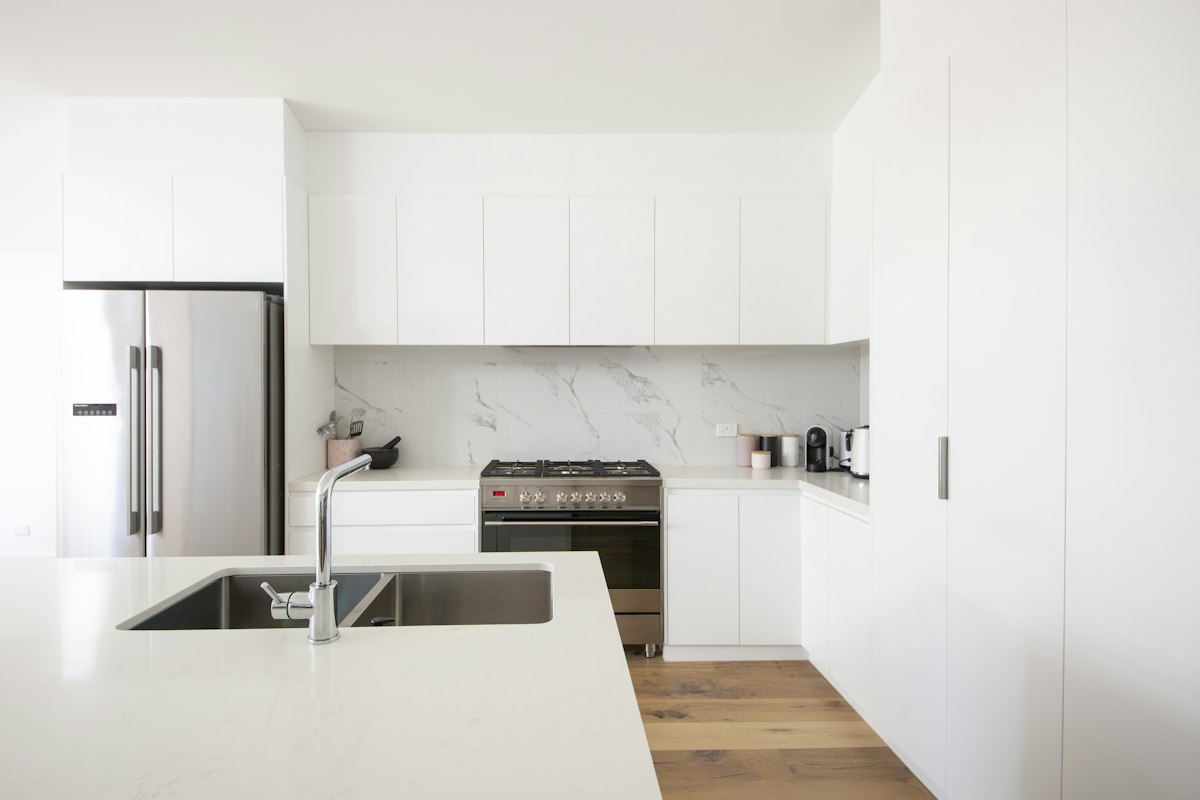 A renovated white kitchen with stone benchtop